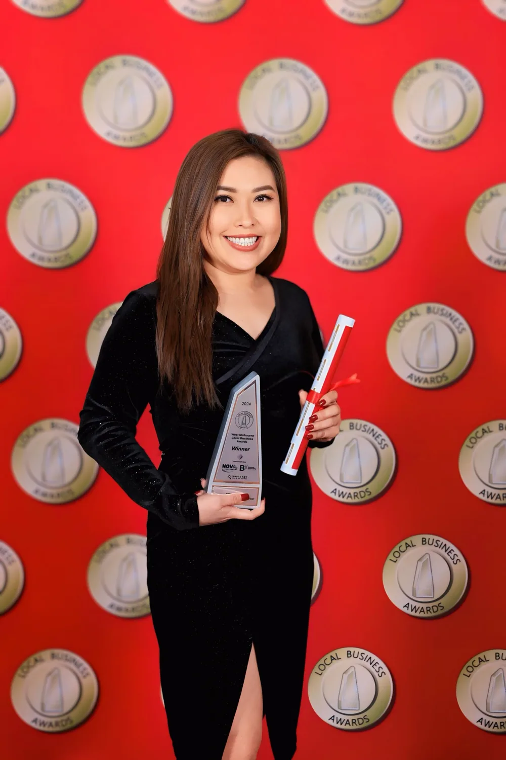 Tina Huynh holding her 2024 Business Person of the Year award